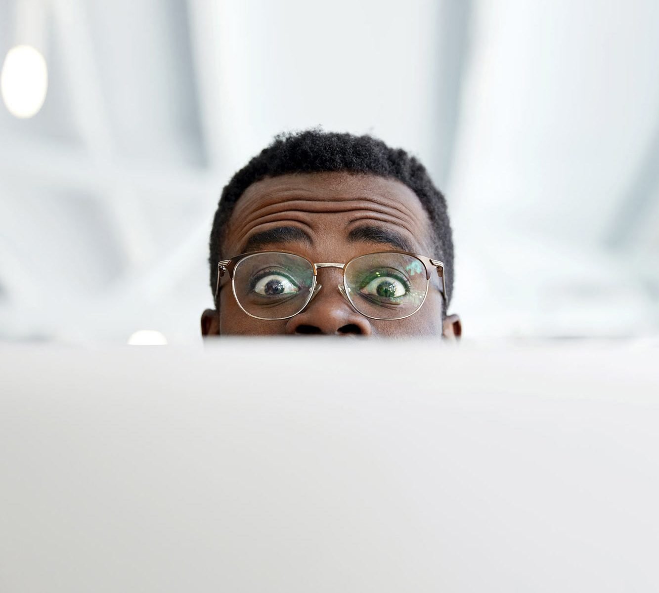 Private practice therapist looking surprised over their laptop about the question of listing fees on their therapist website